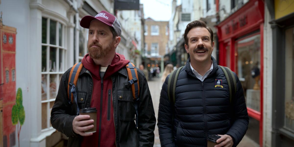 Two men walk down a pedestrian street