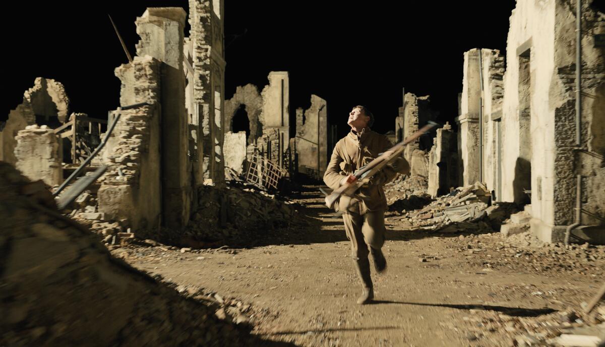 An actor portraying a soldier runs on a bleak landscape
