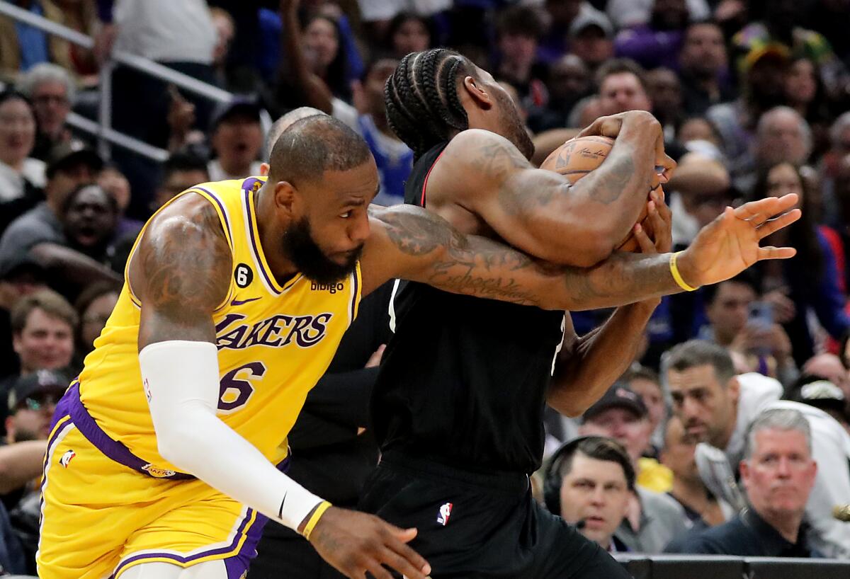 Lakers forward LeBron James gets tangled up with Clippers forward Kawhi Leonard in the third quarter at Crypto.com Arena.
