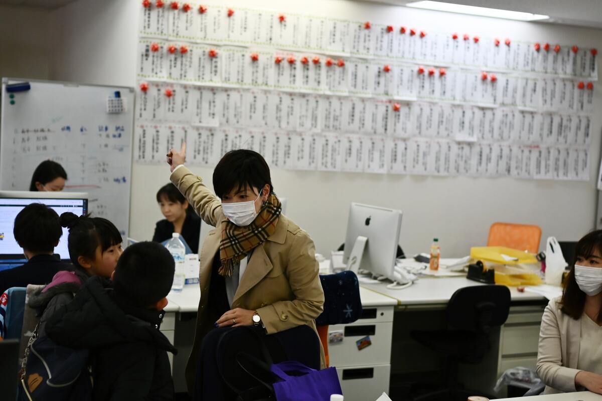 In Tokyo, 40-year-old Mayumi Iijima brought her 8-year-old daughter and 9-year-old son to work last week because schools in Japan were closed due to the coronavirus.