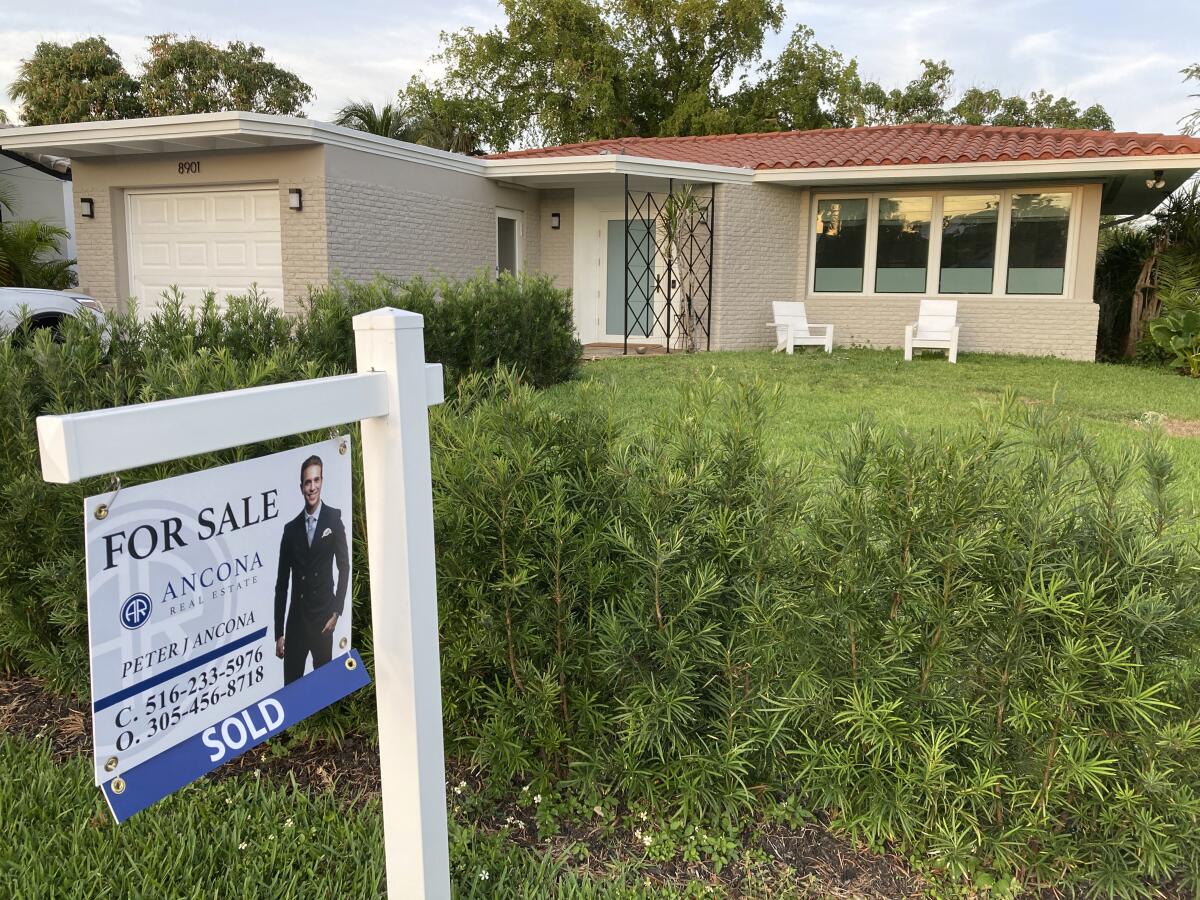 A home with a "sold" sign in front