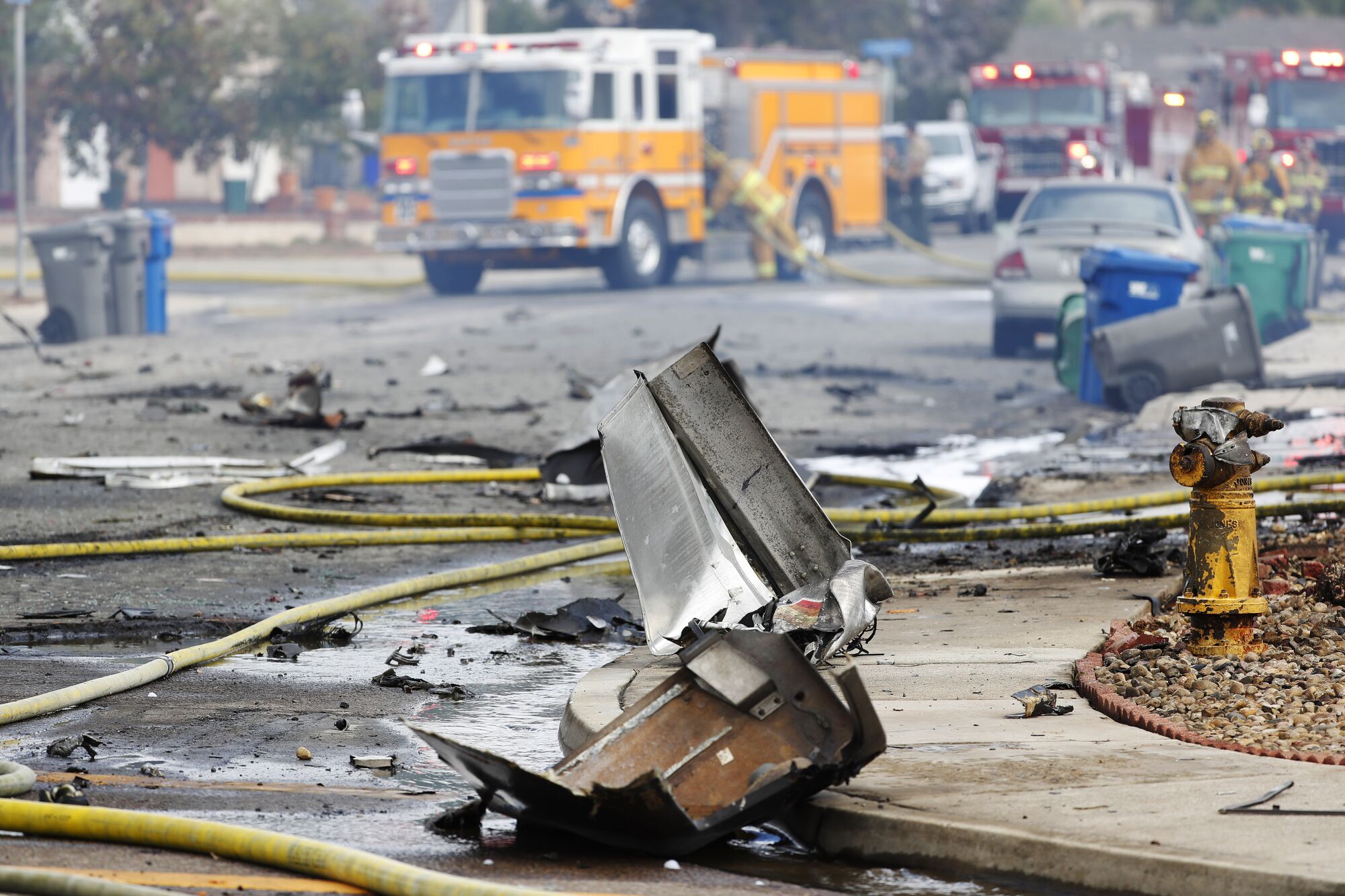 Debris covers the street at the scene of a fatal plane crash on Monday, Oct. 11, 2021 in Santee, CA.