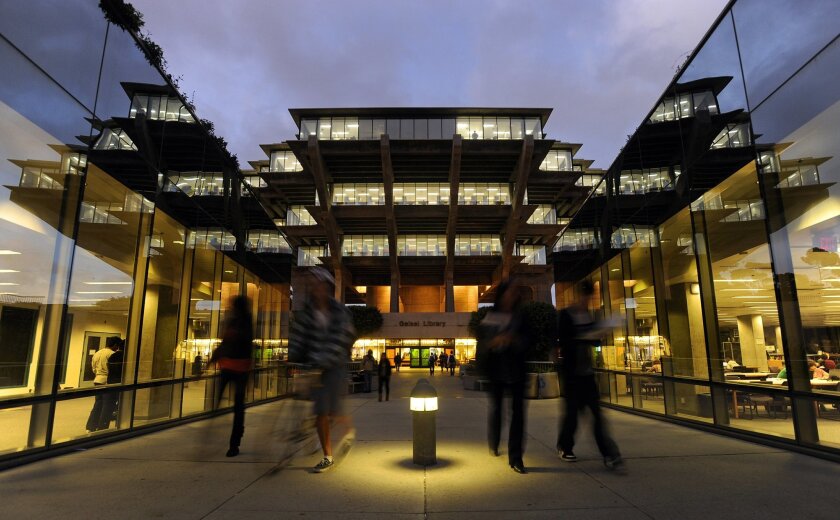 UCSD students walk by the Geisel Library on campus.