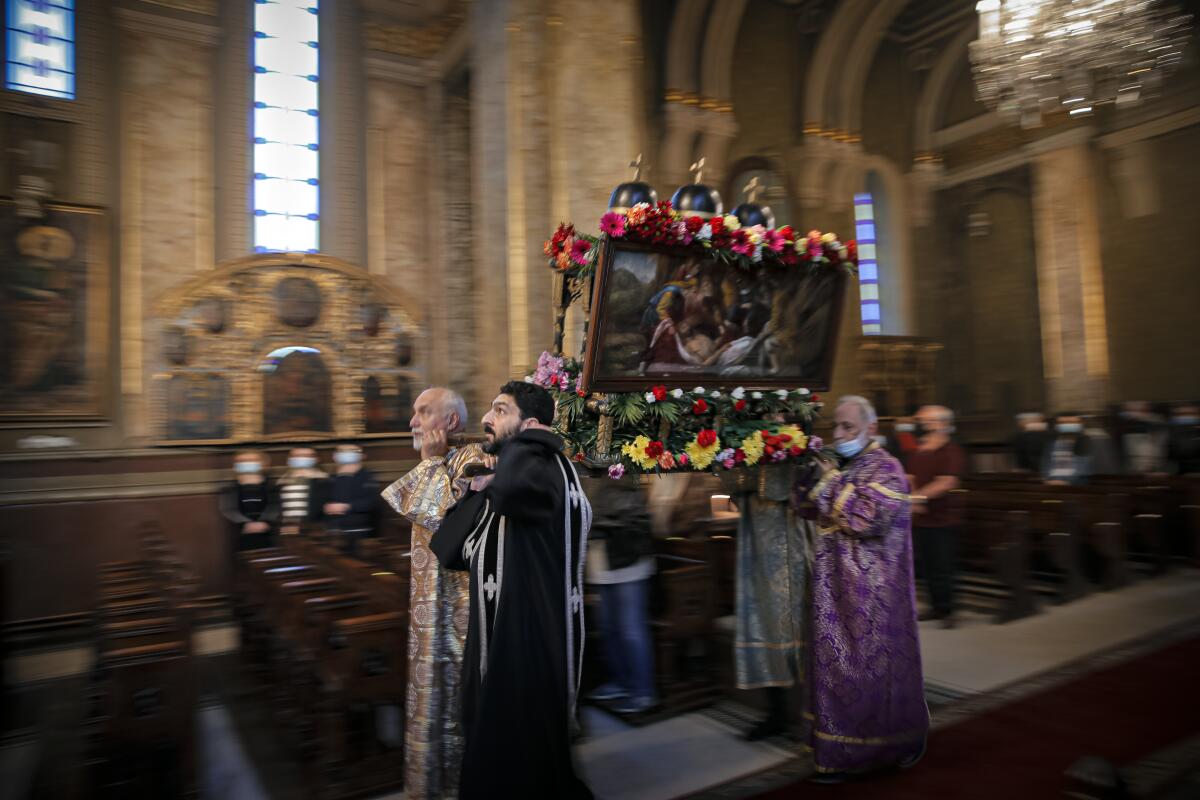 Clergymen carry a structure symbolizing the tomb of Jesus Christ during a Good Friday religious service, at the Armenian Church in Bucharest, Romania, Friday, April 30, 2021. (AP Photo/Vadim Ghirda)
