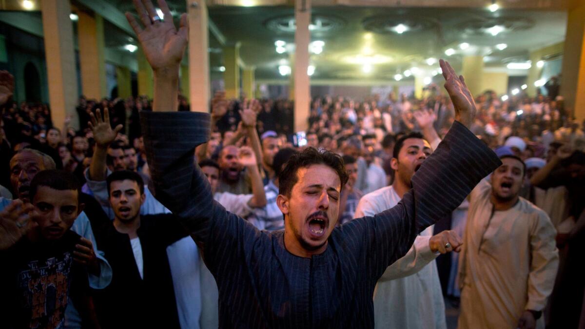 Coptic Christians shout slogans during a funeral service for victims of a bus attack, at Abu Garnous Cathedral in Minya, Egypt, Friday, May 26, 2017.