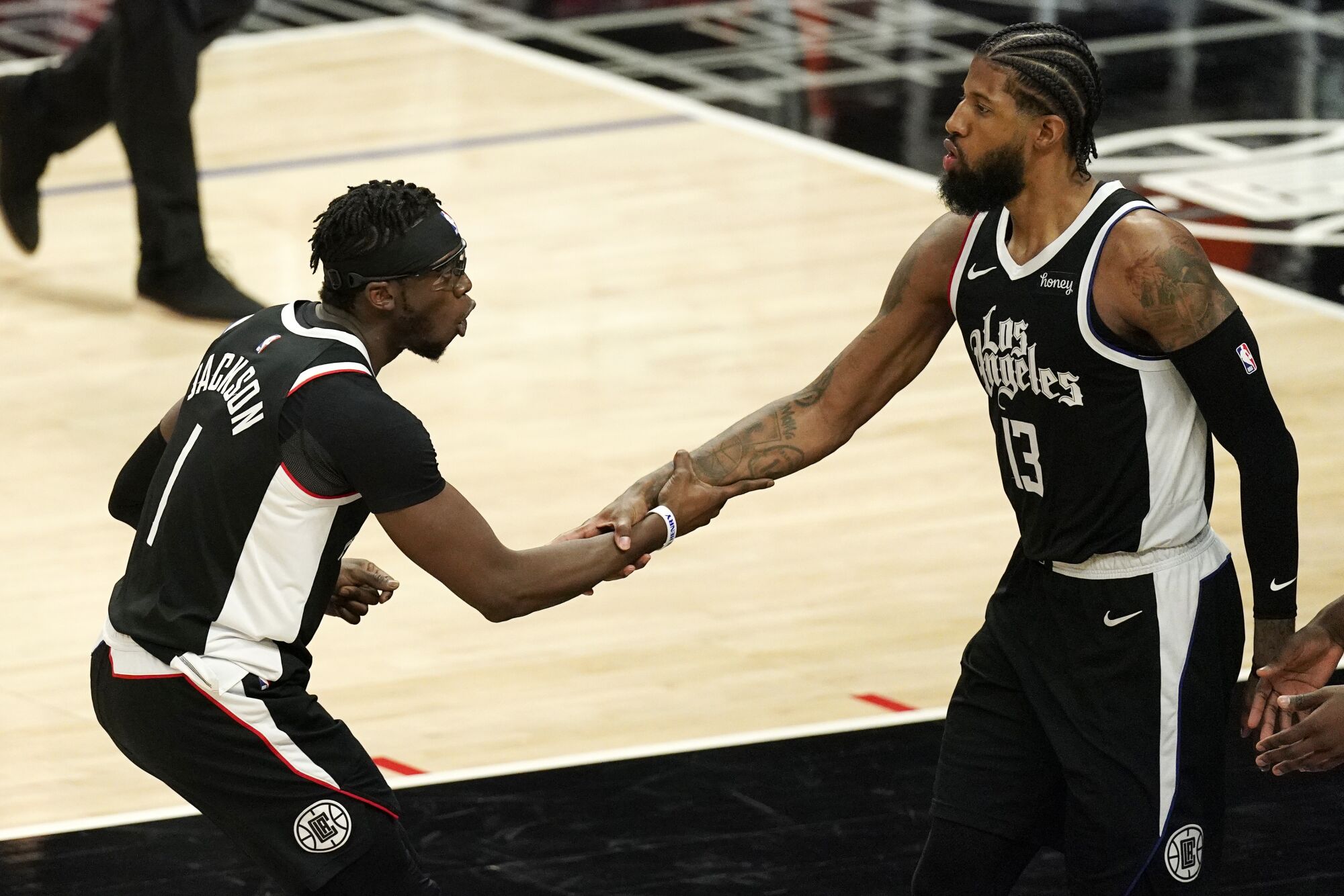 Clippers guard Reggie Jackson, left, congratulates guard Paul George after he scored against the Timberwolves.