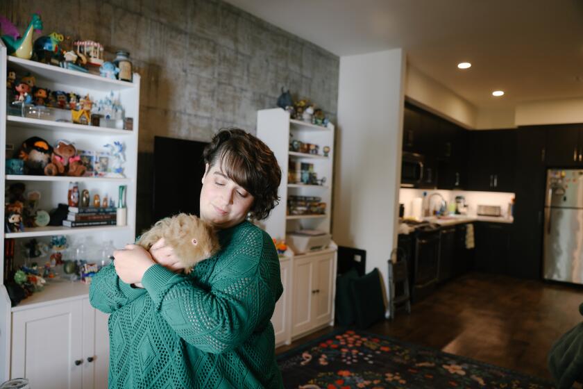 1Pasadena, CA - August 07: Syndey Wright holds "Chewie" at her apartment on Monday, Aug. 7, 2023 in Pasadena, CA. She is a tenant at the Hudson apartment complex which was purchased by a government agency and lowered the rent for middle income tenants because they do not pay property tax, but now officials say tenants may be forced to pay the tax bills. (Dania Maxwell / Los Angeles Times)