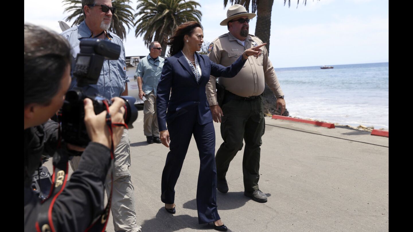 State Atty. Gen. and U.S. Senate candidate Kamala Harris, center, is briefed by Tyson Butzke, right, a superintendent with California State Parks, and Tom Cullen, left, of the Department of Fish and Wildlife, at Refugio State Beach on Thursday.