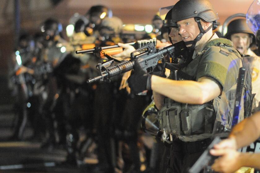 Law enforcement officers facing off against protesters in Ferguson, Mo., after a white police officer shot and killed unarmed black teenager Michael Brown.