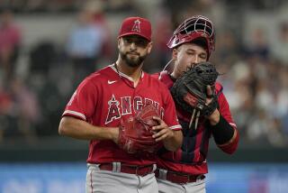 Los Angeles Angels starting pitcher Patrick Sandoval, left, walks off the field while talking to catcher Matt Thaiss.