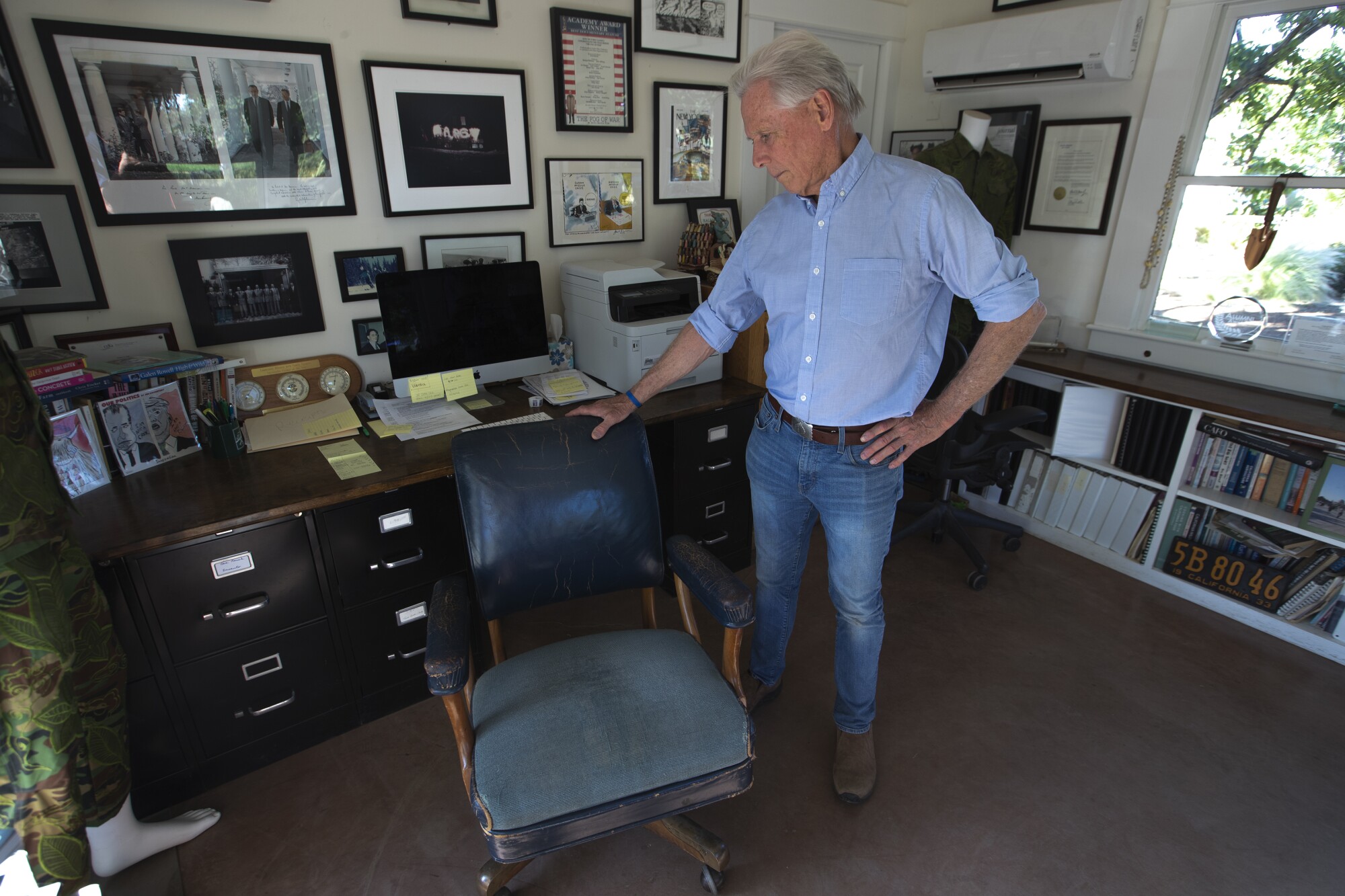 Walnut farmer Craig McNamara stands next to a chair once belonging to his father, Robert McNamara.