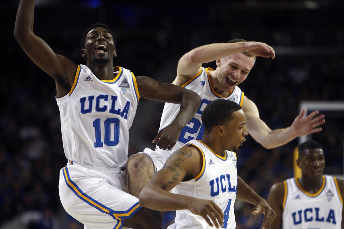 UCLA players Isaac Hamilton (10), Bruce Alford (20) and Norman Powell (4) celebrate a basket in the first half of an 85-74 win against USC.