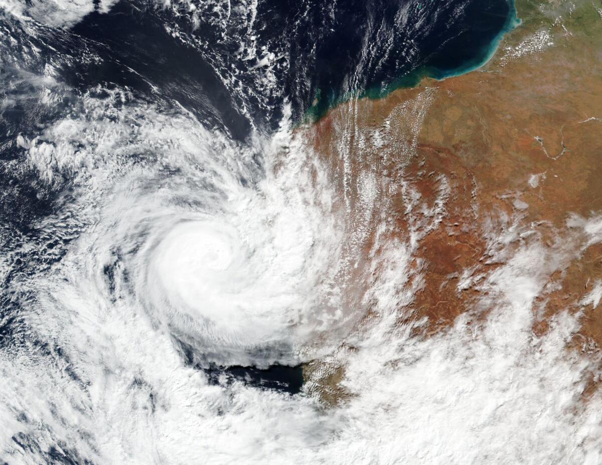 This Sunday, April, 11, 2021, satellite image released by NASA shows Tropical Cyclone Seroja hitting the coast of Western Australia. People living on the coast were preparing themselves Sunday for the landfall of Seroja. (NASA Worldview, Earth Observing System Data and Information System (EOSDIS) via AP)
