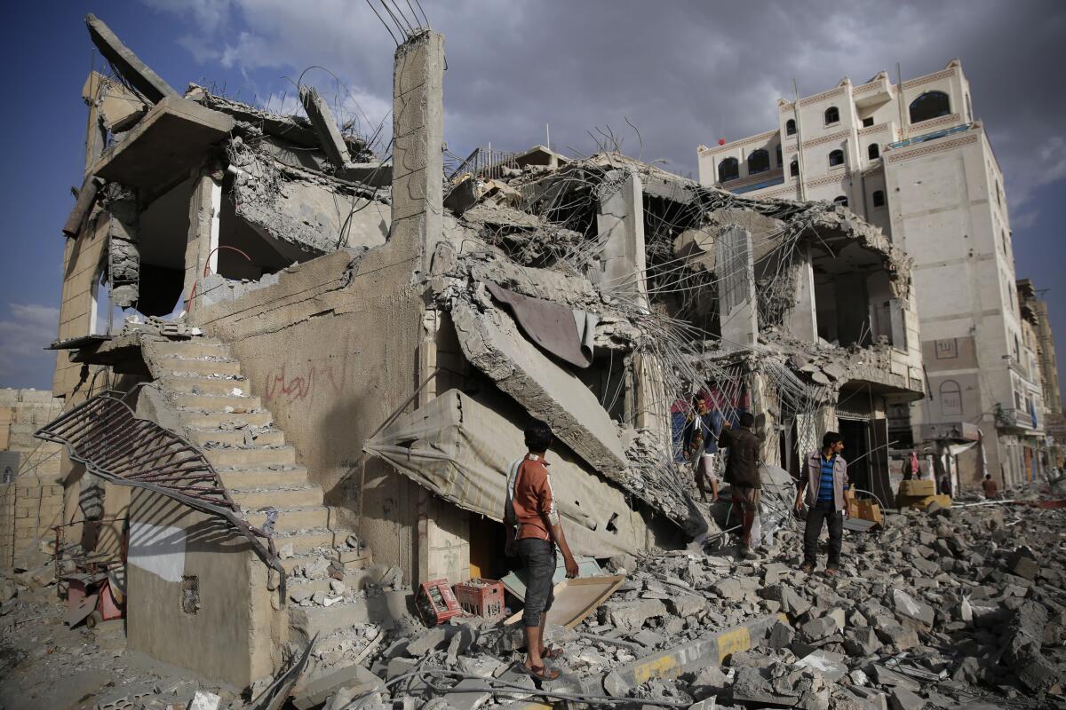 Men inspect a house destroyed by a Saudi-led airstrike in Yemen