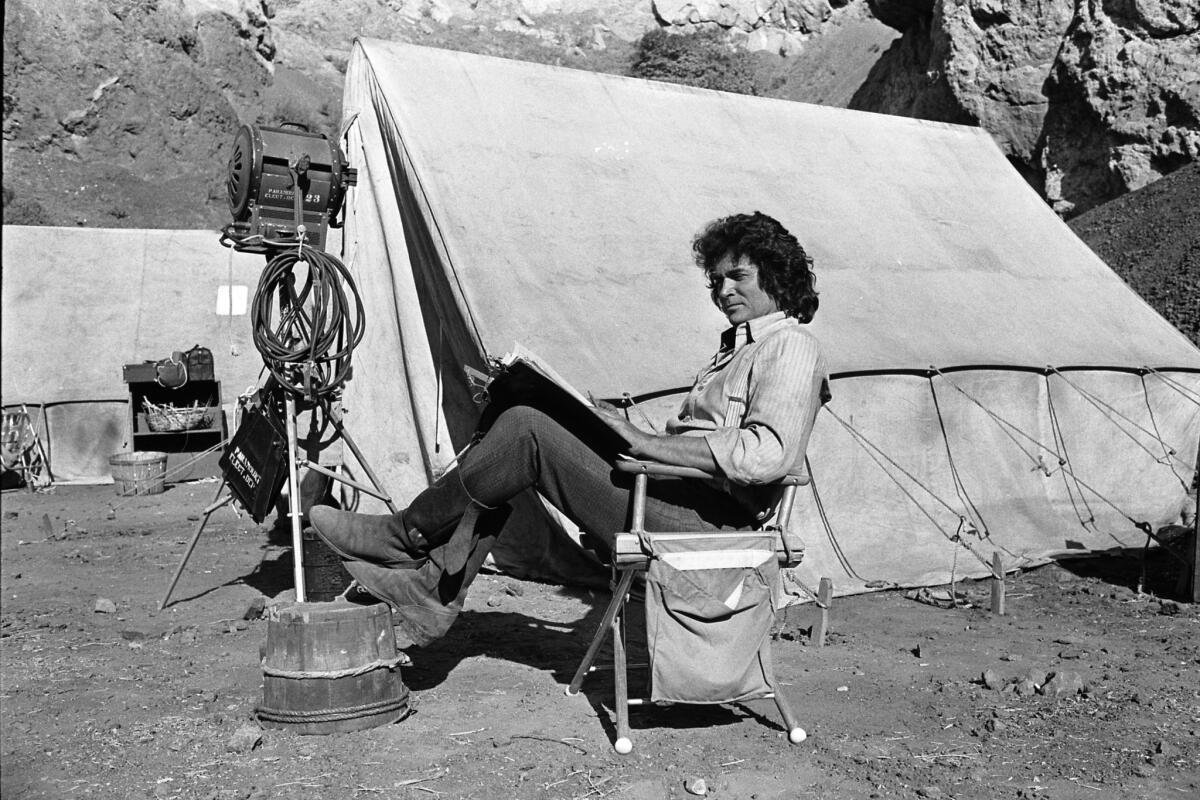 Director and star Michael Landon takes break during filming of the television show "Little House on the Prairie" in 1976 to read a script.