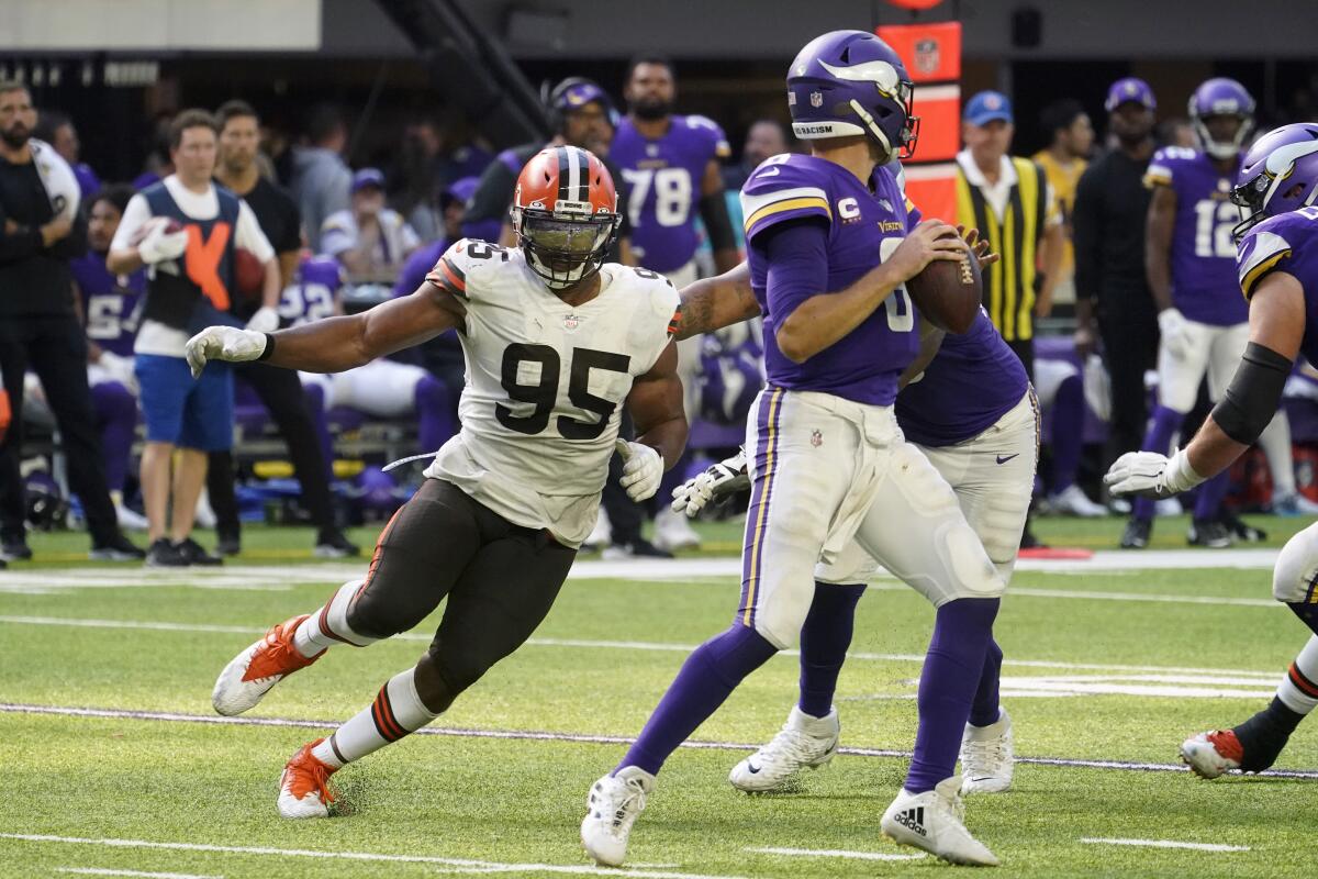 FILE - Cleveland Browns defensive end Myles Garrett (95) pressures Minnesota Vikings quarterback Kirk Cousins (8) during the second half of an NFL football game, Sunday, Oct. 3, 2021, in Minneapolis. Now, more focused, stronger and driven like never before to push himself beyond what he thought possible as he reaches a pivotal point in his NFL career, Garrett has his sights on a new target. He's seeking greatness. Iconic greatness. (AP Photo/Jim Mone, File)