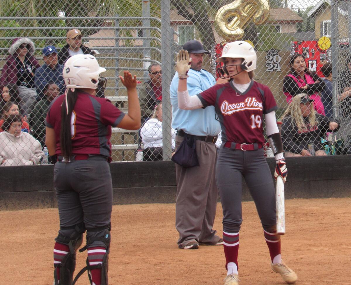 Ocean View's Sienna Erskine (19) and Kaylah Arteaga high-five after Erskine scored in the seventh inning against Katella.