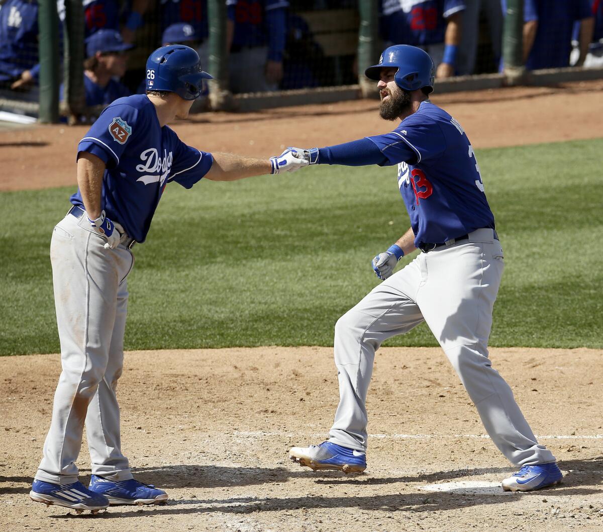 Dodgers outfielder Scott Van Slyke, right, celebrates with Chase Utley after hitting a two-run home run during a spring training game against the Rangers.