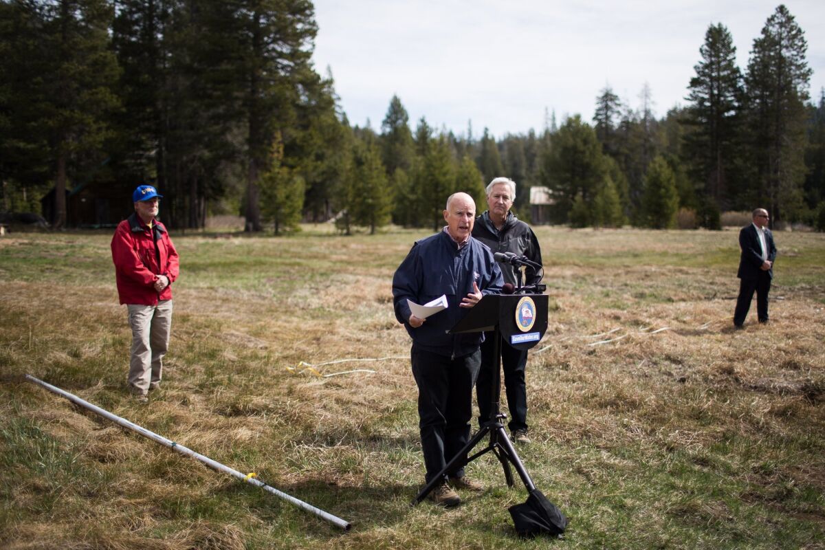 Gov. Jerry Brown speaks during a news conference on mandatory water restrictions Wednesday from an elevation above 7,000 feet in California's Sierra Nevada mountains, which would normally have several feet of snow this time of year.