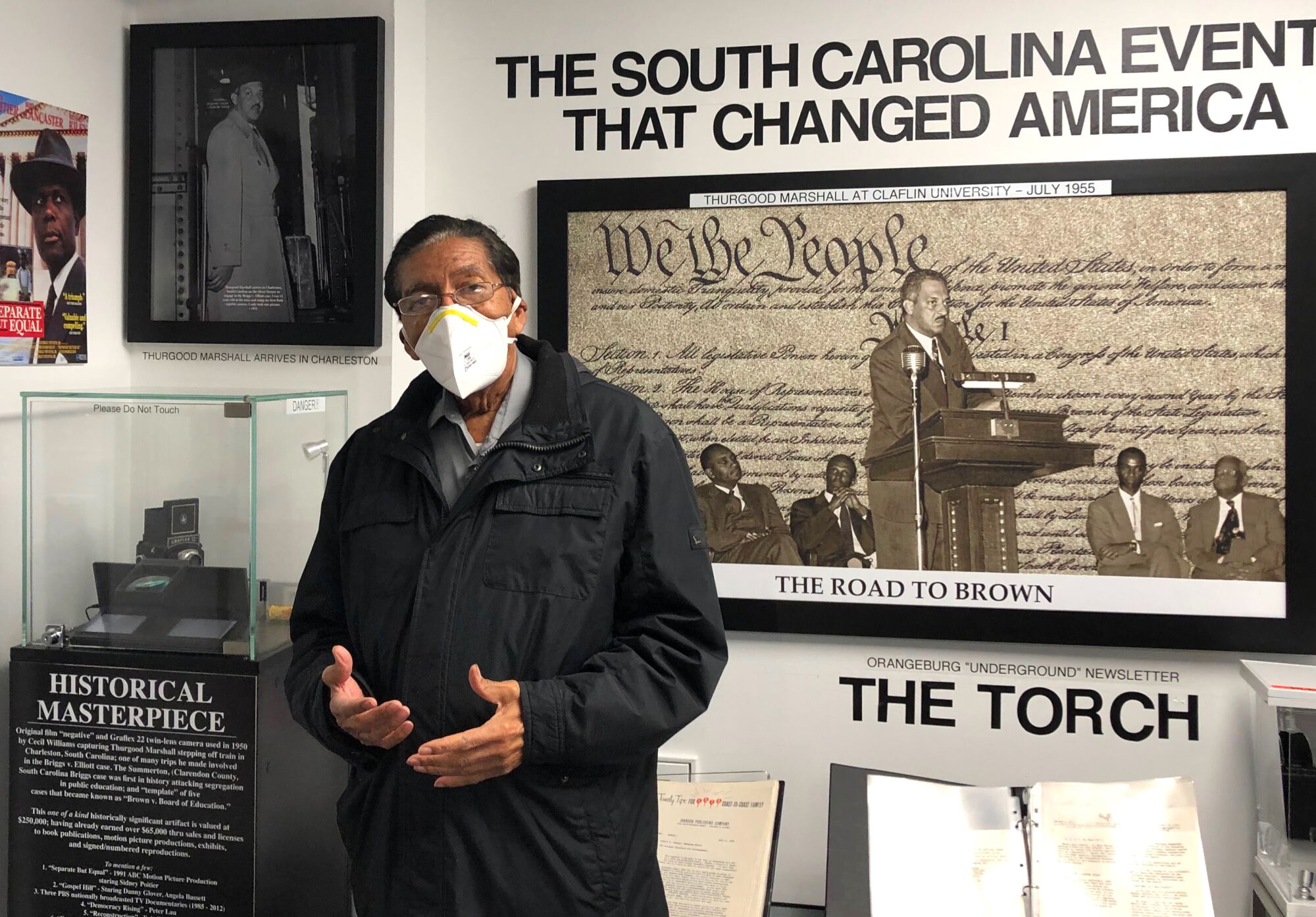 Cecil Williams stands in front of a museum display.