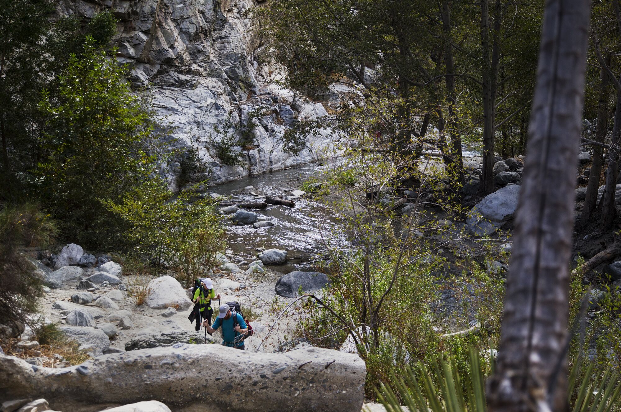 Hikers have to cross streams and the San Gabriel River amid rocky and rugged terrain.