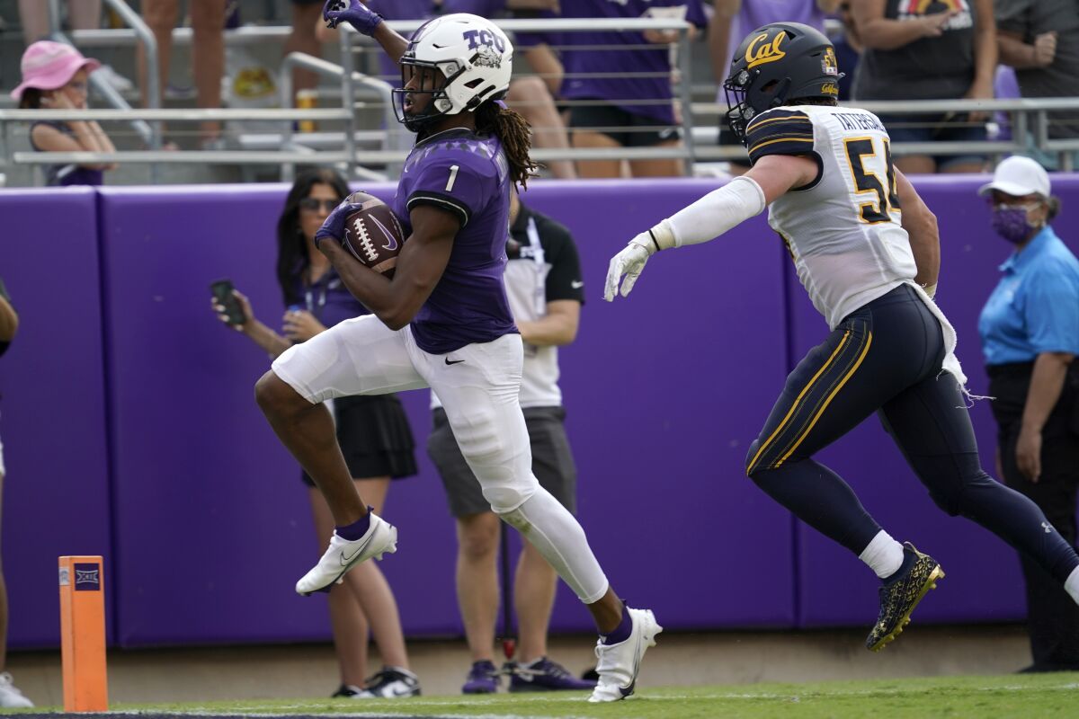 TCU wide receiver Quentin Johnston (1) sprints past California linebacker Evan Tattersall (54) into the end zone for a touchdown after catching a pass in the second half of an NCAA college football game in Fort Worth, Texas, Saturday, Sept. 11, 2021. (AP Photo/Tony Gutierrez)