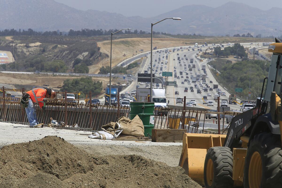 Construction crews work near Green River Road on the 91 Freeway last year. A busy section of the freeway is closed this weekend.