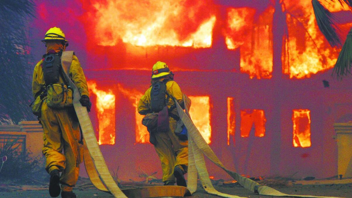 Firefighters battle in Poway during the 2007 wildfires that destroyed more than 1,300 homes.