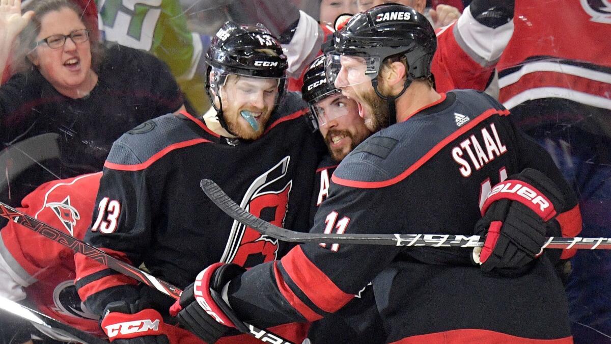 Carolina Hurricanes forward Justin Faulk, center, celebrates with teammates Warren Foegele, left, and Jordan Staal after scoring against the New York Islanders in Game 3 of the NHL Eastern Conference semifinals on May 1.