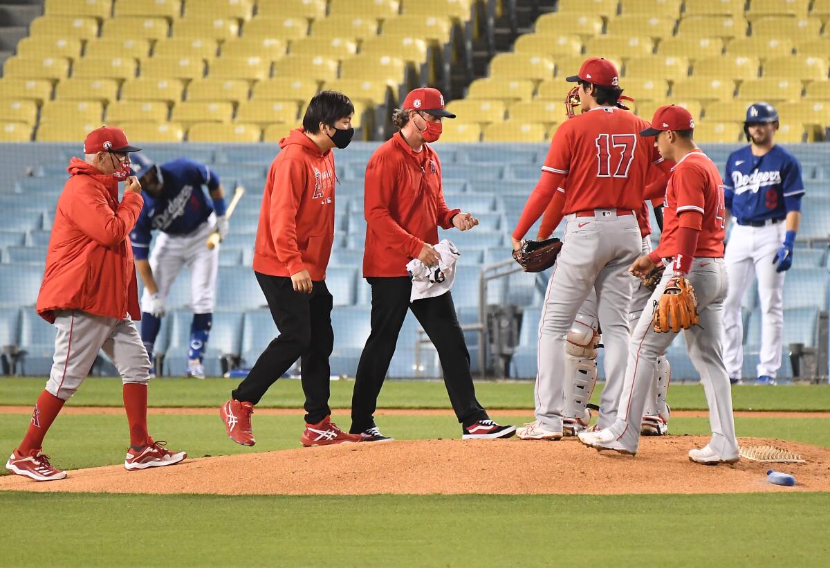 The Angels staff walk to the mound to check on pitcher Shohei Ohtani.