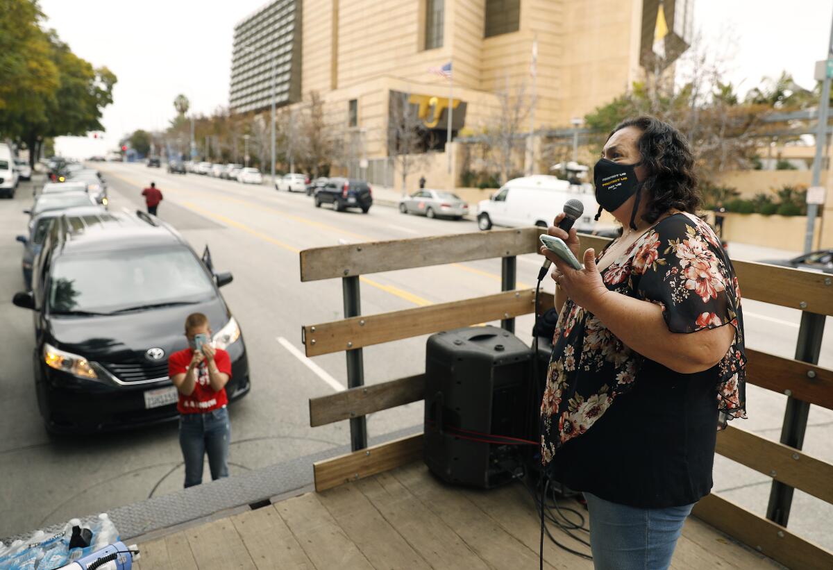 Imelda Rosales, a McDonald's janitor, talks into a microphone at a protest over COVID-19 safety.