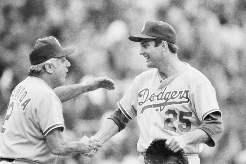 Dodgers manager Tom Lasorda congratulates Tommy John on the mound during the 1978 playoffs 