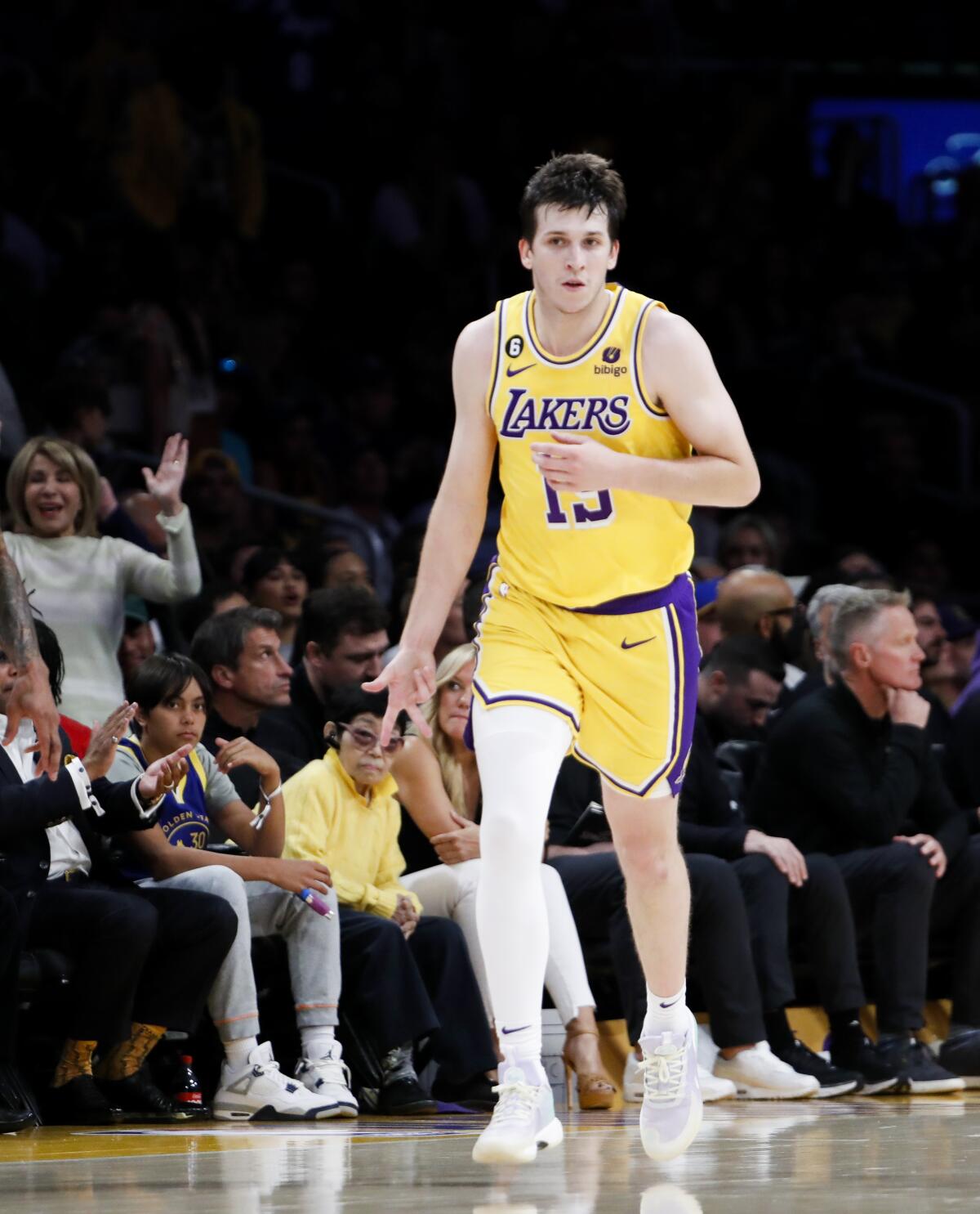 Lakers guard Austin Reaves signals a three-pointer with his right hand.
