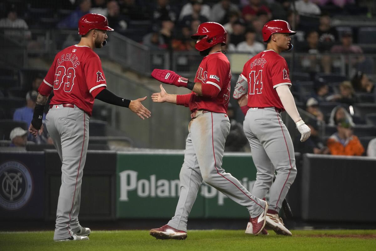 Charles Leblanc, left, and Michael Stefanic, center, celebrate after scoring on a double by Zach Neto.