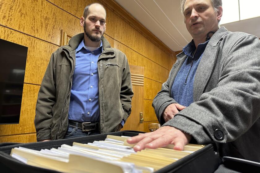 FILE - Retire Congress North Dakota Chairman Jared Hendrix, left, and U.S. Term Limits National Field Director Scott Tillman look over petitions they submitted for a North Dakota congressional age limit ballot initiative, Feb. 9, 2024, at the state Capitol in Bismarck, N.D. On Wednesday, April 3, a top legislative panel unanimously approved a $1 million cost estimate for the state to defend the age limit proposed in a constitutional initiative approved for the June 11 ballot. (AP Photo/Jack Dura, File)