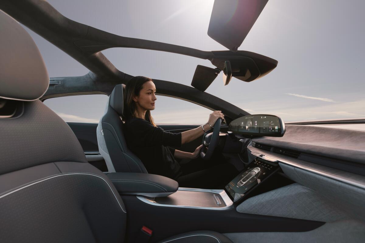 A woman at the wheel of a Lucid Air.