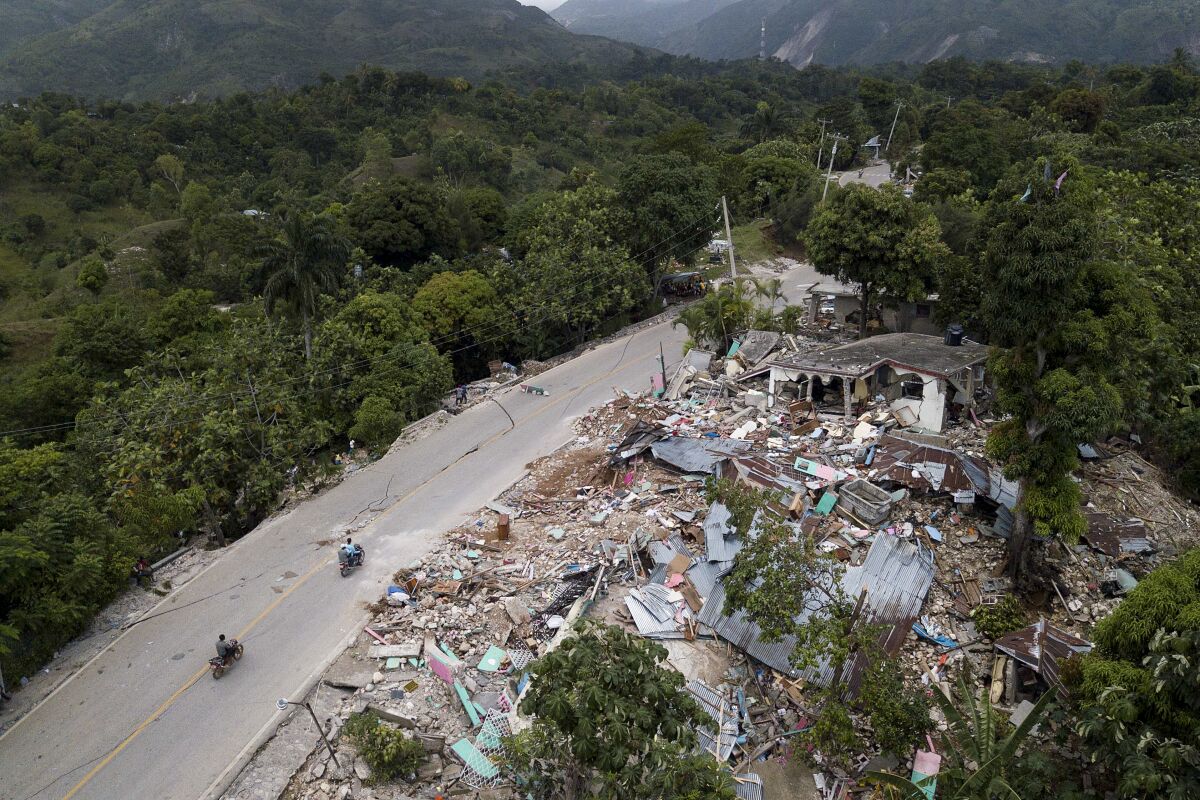 An aerial photo show homes in ruins along an earthquake-damaged road in Rampe, Haiti.