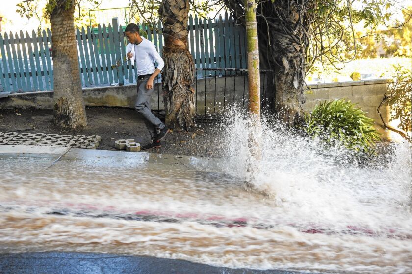 People had to make their way around flowing water along North Olive Drive after a water main break on Sunset Boulevard in West Hollywood last September.