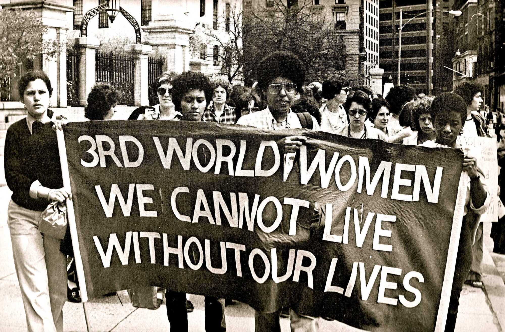 A group of women holds a protest placard in 1979.