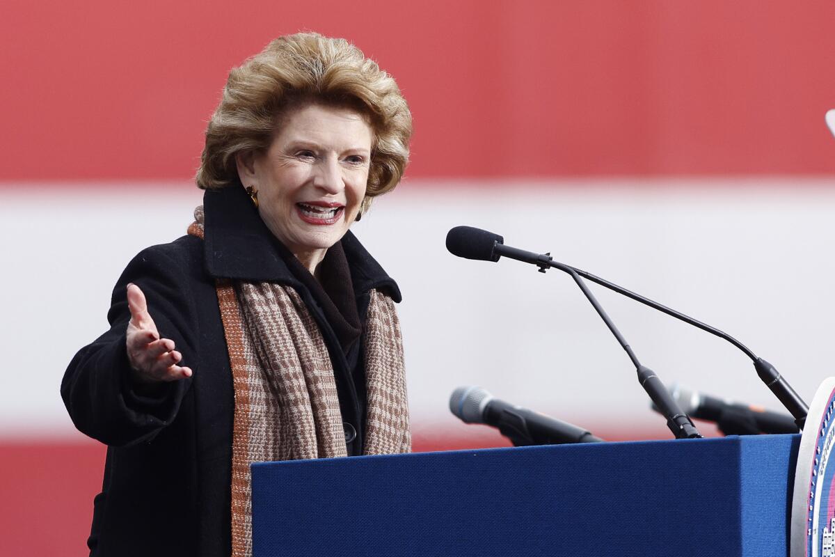 Sen. Debbie Stabenow speaks outside the state Capitol while wearing a coat and scarf.