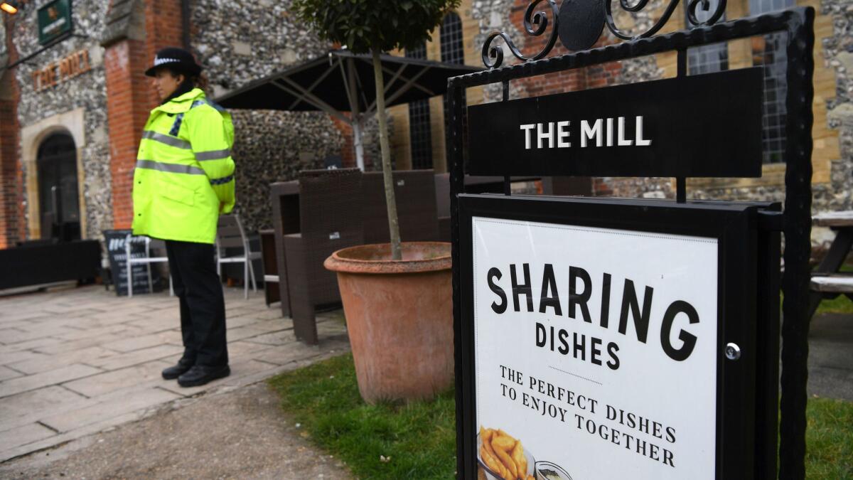 A police officer stands near the cordoned-off Mill pub in Salisbury, England, on Sunday.