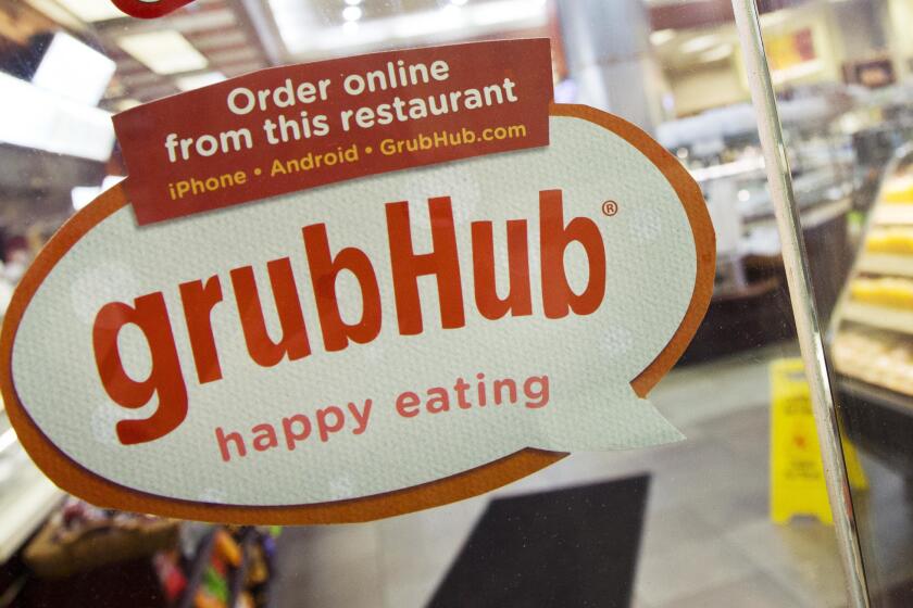 FILE - In this April 4, 2014 file photo, a sign for GrubHub is displayed on the door to a New York restaurant. The owner of KFC and Taco Bell, is teaming up with Grubhub to expand its delivery business. Yum Brands said Thursday, Feb. 8, 2018, that Grubhub will run KFC and Taco Bell delivery and online ordering in the United States. GrubHub will provide delivery people and its technology.(AP Photo/Mark Lennihan, File)