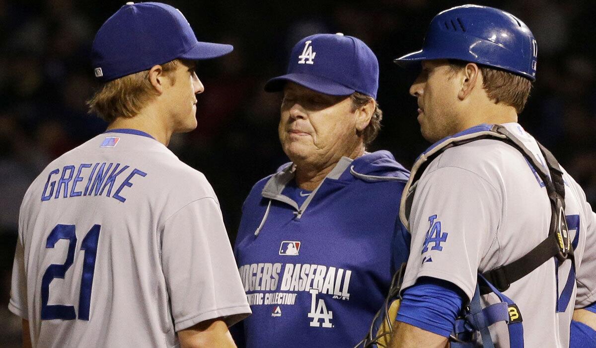 Pitching coach Rick Honeycutt talks to starter Zack Greinke and catcher A.J. Ellis during the Dodgers' game against the Chicago Cubs on Sept. 18.