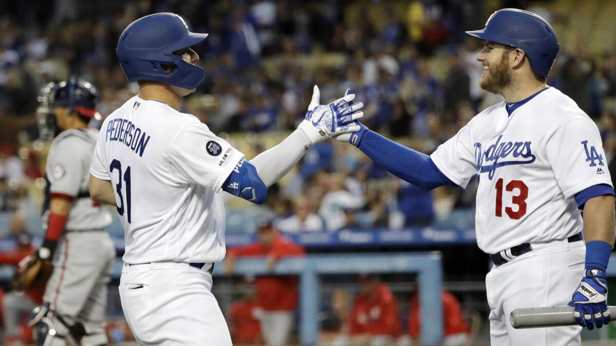 Joc Pederson greets teammate Max Muncy after Pederson's solo home run against the Washington Nationals during the first inning on Friday at Dodger Stadium.