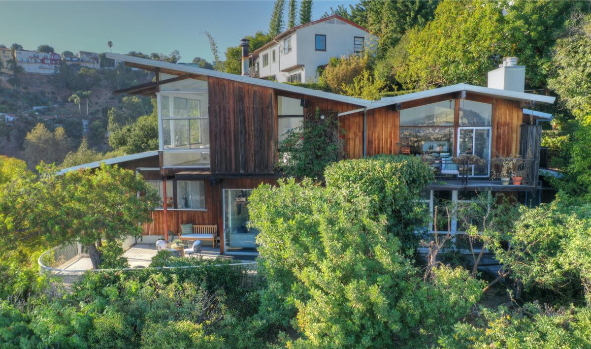 Built in 1951, this Midcentury post-and-beam home features an eye-catching exterior of wood and glass.