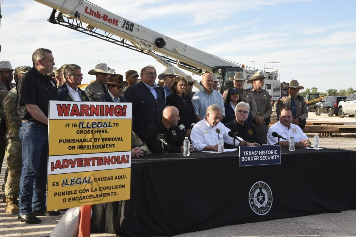Texas Gov. Greg Abbott signing bills into law at a border wall construction site