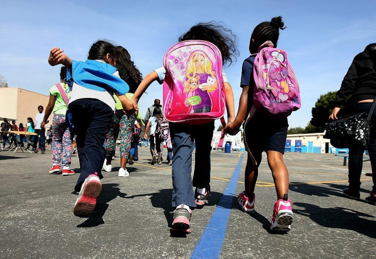 Harvard social scientist Robert Putnam's new book "Our Kids" analyzes inequality among the nation's children. Above, school children hold hands on the Grape St. Elementary playground in Watts.