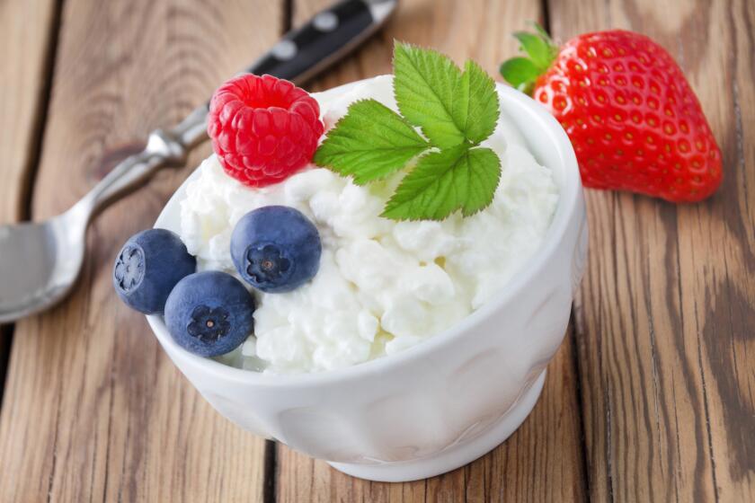 Cottage Cheese and fruits against wooden background