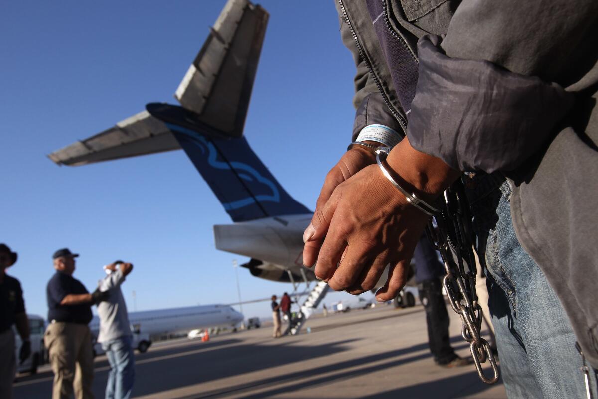 A migrant in chains prepares to board a deportation flight to Guatemala City at Phoenix-Mesa Gateway Airport in Mesa, Ariz.