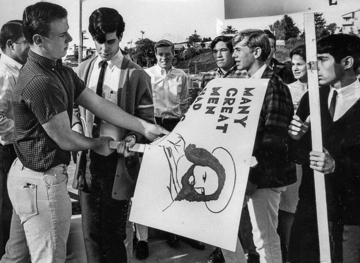 March 7, 1966: Mike Rockwell, a football player, rips one of the protest signs.